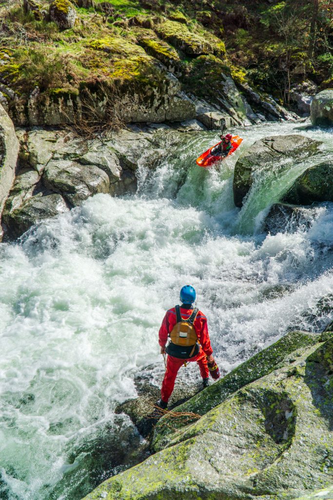 Adventurers navigating turbulent rapids in Occitanie's scenic waterfalls, France. Action-packed kayaking.